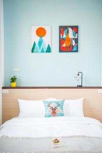 马公起点旅行的卧室配有一张壁画和两张画的床铺。