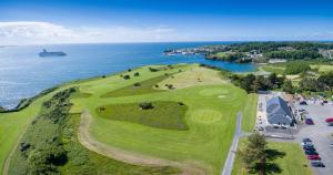 邓莫尔东Dunmore East Holiday and Golf Resort Apartments的享有毗邻大海的高尔夫球场的空中景致