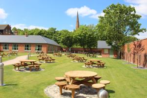 伯明翰The Aston Tavern的庭院里一组野餐桌和长凳