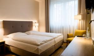 汉堡Haus Rissen Gaestehaus的卧室设有一张白色大床和一扇窗户。
