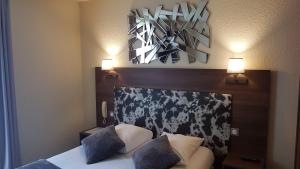 尼奥尔Hotel Atoll的卧室配有一张床,墙上有两盏灯