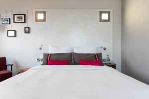 德比pentahotel Derby的卧室配有带红色枕头的大型白色床