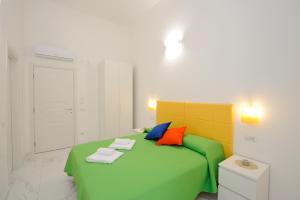 阿马尔菲B&B Valentì的一间卧室配有带色彩缤纷的枕头的绿色床