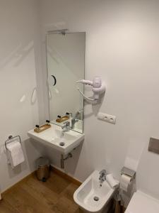 佩德勒纳hotel la trainera的白色的浴室设有水槽和镜子