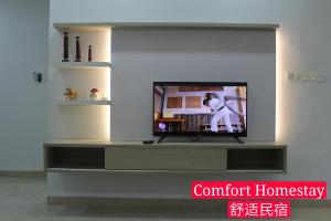 麻坡Muar Homestay (Comfort Homestay)的客厅设有电视,带娱乐中心
