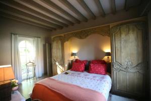 萨勒布里Haras du Vignault的一间卧室配有一张带红色枕头的大床