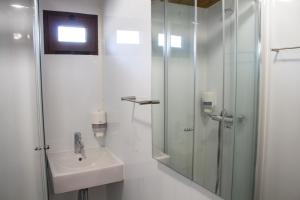 Janeiro de Baixoxisto camping的白色的浴室设有水槽和淋浴。