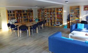 比丁赫伊曾Bungalowpark De Bremerberg的客厅配有桌椅和书架