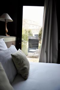 尼奥尔巴尔迪库里尔酒店的一间卧室配有一张床和一个带椅子的窗户