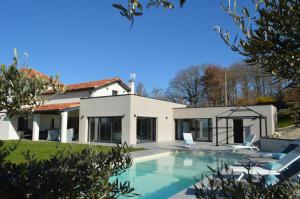 CaumontVilla au coeur du Gers avec vue sur les Pyrénées的一座房子前面设有游泳池