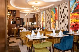 里斯本Be Poet Baixa Hotel的餐厅设有桌椅,墙上挂有绘画作品