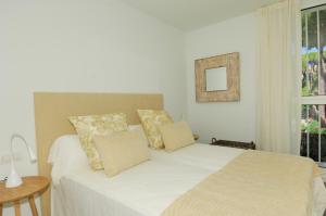 卡莱利亚德帕拉弗鲁赫尔Luxury Central Apartments, Illa Blanca, Calella的卧室配有带枕头的白色床和窗户。