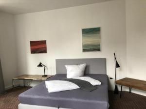 吕登沙伊德Schillers Hotel & Café - GARNI -的一间卧室配有一张带书桌的床和两个枕头。