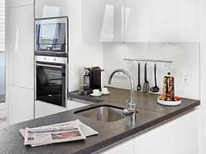 杜塞尔多夫红色公寓酒店的一个带水槽的厨房和柜台上的报纸