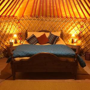 基尔肯尼McClure Yurt at Carrigeen Glamping的蒙古包内一间卧室,配有一张床