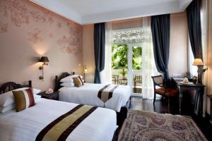 清迈平中良精品酒店的酒店客房设有两张床和窗户。