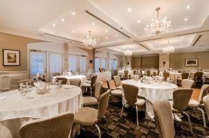 拉瓦尔圣马丁套房酒店的宴会厅配有桌椅和吊灯。