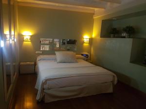 布宜诺斯艾利斯Uman Hotel -Motel-的卧室配有一张带两盏灯的墙壁床。