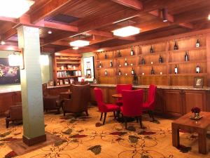 桑塔妮拉观澜德奥罗即酒店的一间酒吧,里面摆放着红色的椅子和桌子