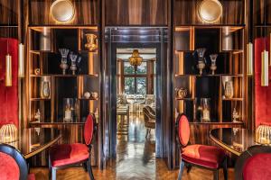 梅拉诺Villa Eden a member of Leading Hotels of the World的用餐室设有木镶板和红色的椅子和桌子