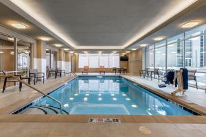 奥马哈Cambria Hotel Omaha Downtown的一座配有桌椅的酒店游泳池