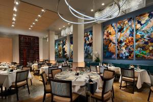 圣地亚哥拉霍亚格兰德科隆尼酒店的一间带桌椅的用餐室和一幅大画