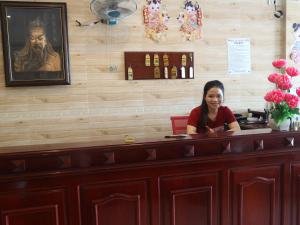 河仙Nhà Nghỉ BẢO CHÂU的坐在餐厅柜台的女人