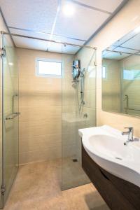 曼谷Sound@sleep Hotel的一间带玻璃淋浴和水槽的浴室