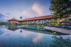 卡卢特勒Anantara Kalutara Resort的一座带游泳池的度假村,位于一座建筑前