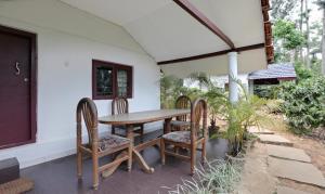 马迪凯里Itsy By Treebo - Jammabane Cottage With Mountain View的天井上的木桌和椅子