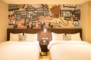 台北享住旅店-台北火车站的两张位于酒店客房的床,墙上挂着壁画