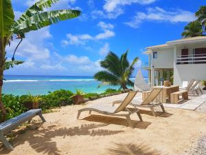 拉罗汤加海洋喷雾别墅酒店的海边带椅子的房子