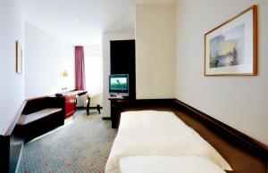 科隆帝国酒店的酒店客房,配有床和电视