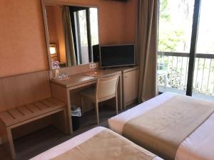 卢恰纳瓦尔特家庭酒店的酒店客房配有一张书桌、一台电视和一张床