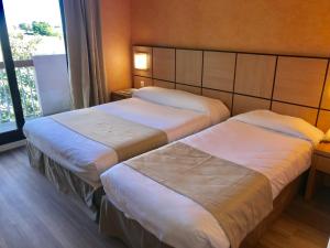 卢恰纳瓦尔特家庭酒店的酒店客房设有两张床和窗户。