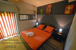 图阿马西纳La Maison的一间小卧室,内有橙色的床