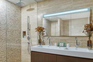 比尔根山Bürgenstock Residences Suites的浴室配有盥洗盆和带镜子的淋浴