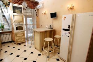 第聂伯罗Апартаменты возле Вокзала, Центр的厨房配有冰箱、桌子和凳子