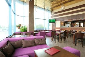 莫斯科Park Tower的一间设有紫色长沙发和桌子的餐厅和一间酒吧