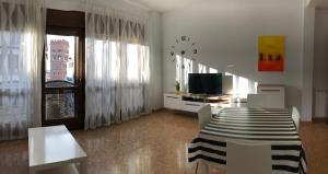 特鲁埃尔Apartamento Centro Historico Teruel的客厅配有桌椅和电视。