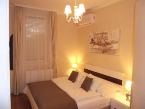 赫维兹Ametiszt Apartman的一间卧室配有一张带白色床单的床和一扇窗户。
