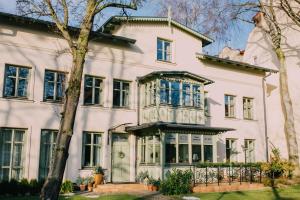 索波特Villa Sopocka的白色的大房子,设有蓝色的窗户
