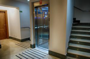 莱昂勒佩提特莱昂酒店的大楼内带玻璃电梯的走廊