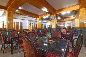 班贾尔马辛Hotel SAS Syariah的餐厅内带桌椅的用餐室