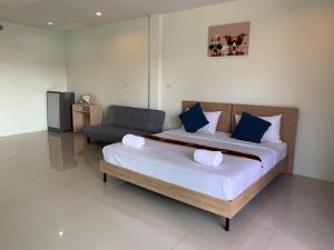 奈扬海滩Khao Oat airport的一间卧室配有一张大床和一把椅子