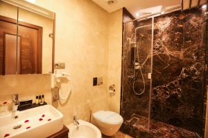 卡萨布兰卡Suite Hotel Casa Diamond的带淋浴、盥洗盆和卫生间的浴室
