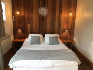 卡普费雷蓝旗酒店的一间卧室配有一张带两盏灯的大型白色床。