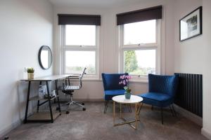 吉尔福德阿斯帕里安酒店的一个带两把椅子和一张桌子的办公室和两扇窗户