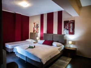 阿利韦里翁Gina's Studios的一间卧室配有两张红色和白色条纹的床