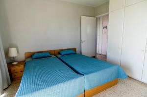 拉纳卡Blue Bay Beach House的一间卧室配有两张蓝色床单